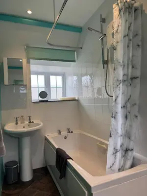 a bathroom with a tub and a sink and a shower at Titmouse at Trenale Court Cottages in Tintagel