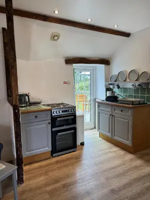 a kitchen with a stove and a counter top at Titmouse at Trenale Court Cottages in Tintagel