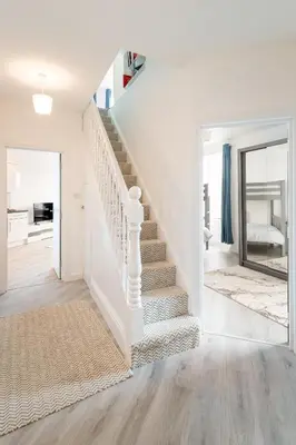 a white staircase in a living room with white walls at Trehawke House in Liskeard
