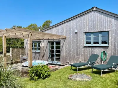 a backyard with two chairs and a building at The Dairy - Luxurious Hideaway on The Lizard in Cury