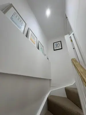 a staircase in a house with white walls at Bagnalls Cottage, A newly renovated cottage in the heart of the Downalong, St Ives moments from the harbour beach in St Ives