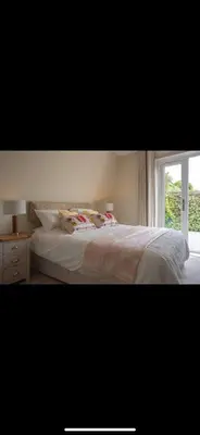 a bedroom with a bed and a window at 3 Bed Stylish Beachfront Retreat in Roche