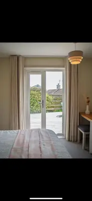 a bedroom with a bed and a sliding glass door at 3 Bed Stylish Beachfront Retreat in Roche