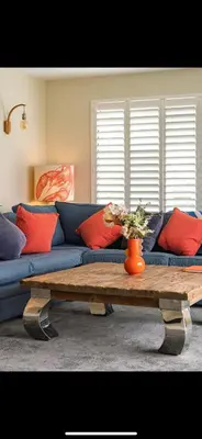 a living room with a blue couch and a coffee table at 3 Bed Stylish Beachfront Retreat in Roche