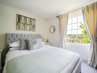 a bedroom with a large bed and a window at Polmear Farm House in Charlestown