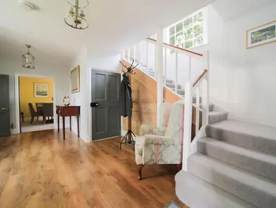 a living room with stairs and a chair at Polmear Farm House in Charlestown