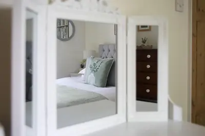 a mirror reflection of a bed in a bedroom at Polmear Farm House in Charlestown