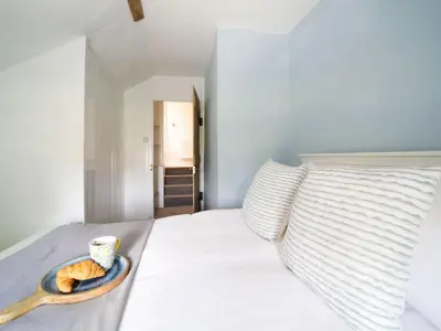 a bed with a bowl of cookies and a cup on it at Polmear Farm House in Charlestown