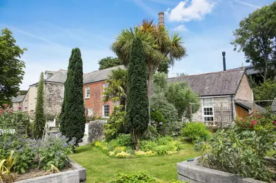an old house with a garden in front of it at Polmear Farm House in Charlestown
