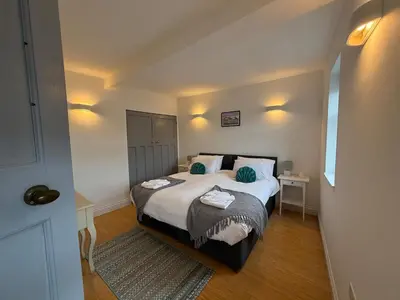 a bedroom with a large bed with blue pillows at Modern Town Centre Flat in St Austell