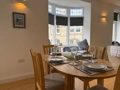 a dining room table with plates and glasses on it at Modern Town Centre Flat in St Austell