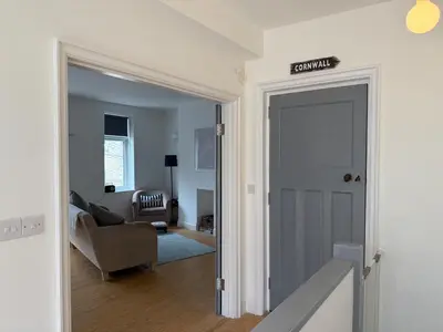 a hallway with a door leading to a living room at Modern Town Centre Flat in St Austell