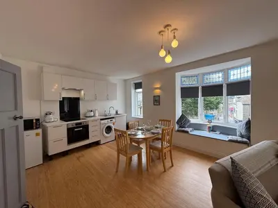 a kitchen and dining room with a table and chairs at Modern Town Centre Flat in St Austell