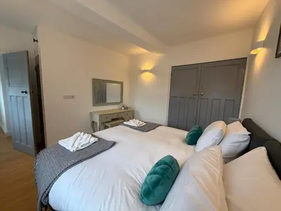 a bedroom with a large white bed with green pillows at Modern Town Centre Flat in St Austell