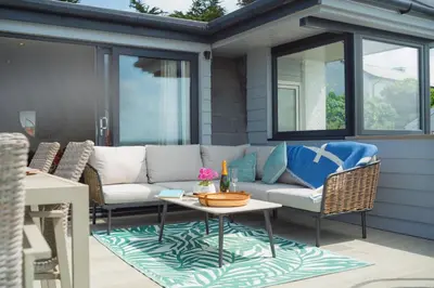 a patio with a couch and chairs and a table at FERRYPOINT - 3 Bed Stylish Beachfront Retreat in Padstow