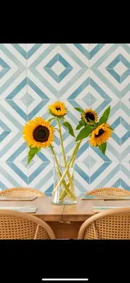 a vase filled with sunflowers sitting on a table at FERRYPOINT - 3 Bed Stylish Beachfront Retreat in Padstow