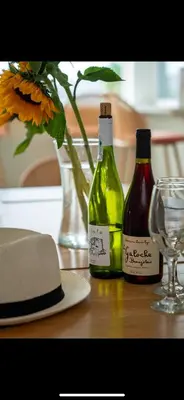 two bottles of wine sitting on a table with a glass at FERRYPOINT - 3 Bed Stylish Beachfront Retreat in Padstow