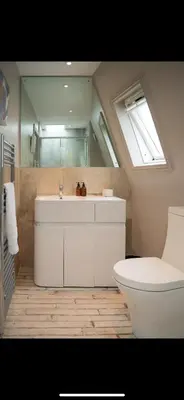 a bathroom with a toilet and a sink and a window at FERRYPOINT - 3 Bed Stylish Beachfront Retreat in Padstow