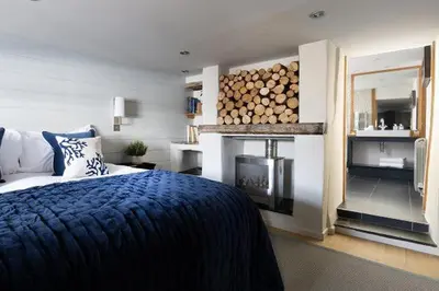 a bedroom with a bed and a fireplace with a fire place at Bryn Cottage in Padstow
