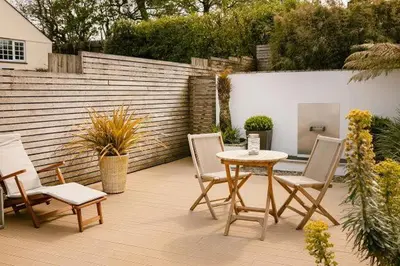 a patio with a table and chairs and a fence at Bryn Cottage in Padstow