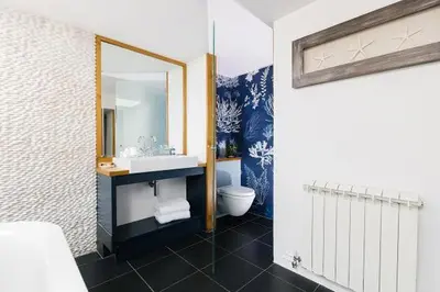 a bathroom with a sink and a mirror and a toilet at Bryn Cottage in Padstow