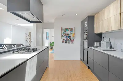 a kitchen with white counters and a stove top oven at Finest Retreats - Tregarden in Bude