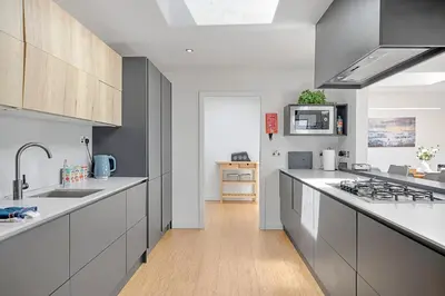 a kitchen with white counters and gray cabinets at Finest Retreats - Tregarden in Bude