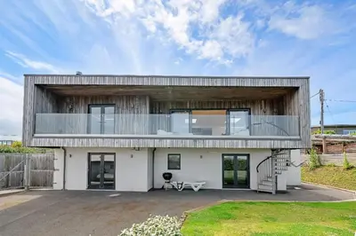 a large white house with a balcony on top of it at Finest Retreats - Tregarden in Bude