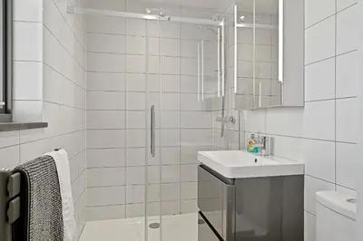 a white bathroom with a sink and a shower at Finest Retreats - Tregarden in Bude