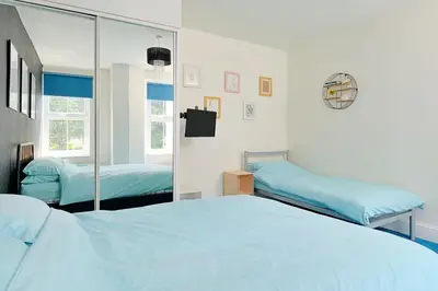 a bedroom with two beds and a mirror at Finest Retreats - Lansdowne in Falmouth