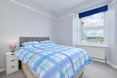 a white bedroom with a bed and a window at Finest Retreats - Lansdowne in Falmouth