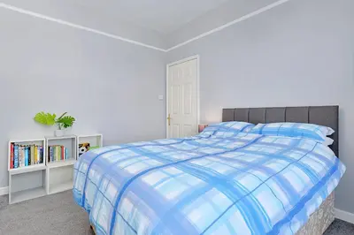 a bedroom with a bed with a blue and white comforter at Finest Retreats - Lansdowne in Falmouth