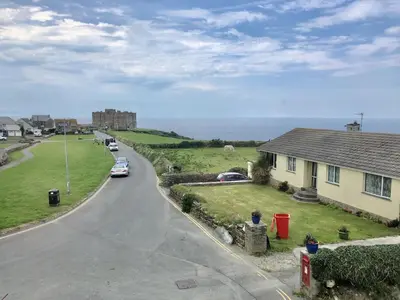 a street with a house and a car on the road at Pendrin Guest House in Tintagel