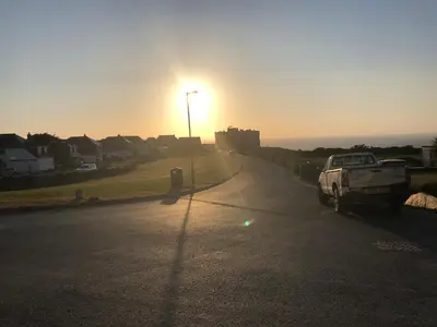 a truck parked on a street with the sun setting at Pendrin Guest House in Tintagel