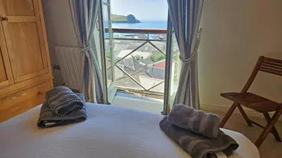 a bedroom with a bed with a view of the ocean at Crow's Nest in Saint Mawes