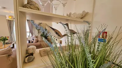 a living room with a large mirror and some plants at Crow's Nest in Saint Mawes