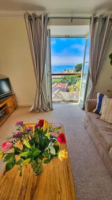 a living room with a vase of flowers on a table at Crow's Nest in Saint Mawes