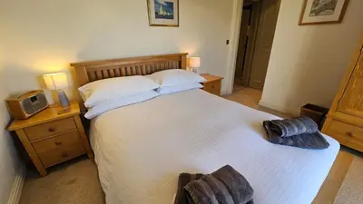 a bedroom with a large white bed with two pillows at Crow's Nest in Saint Mawes