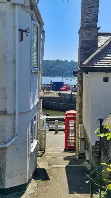a building and a red phone booth next to a building at Crow's Nest in Saint Mawes