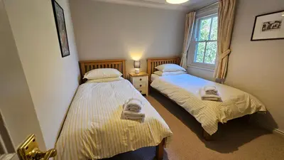 two twin beds in a room with a window at Crow's Nest in Saint Mawes