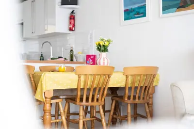 a kitchen with a yellow table and chairs at 15 Barnaloft in St Ives