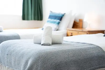 a bedroom with two beds with towels on them at 15 Barnaloft in St Ives