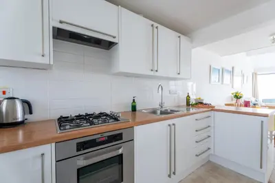 a kitchen with white cabinets and a stove top oven at 15 Barnaloft in St Ives