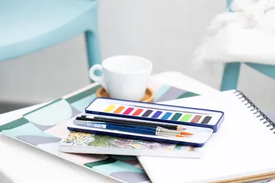 a stack of colored pencils and a cup on a table at 15 Barnaloft in St Ives