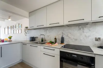 a white kitchen with white cabinets and a sink at 17 Barnaloft in St Ives