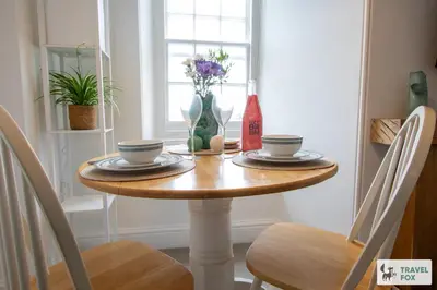 a dining room table with plates and flowers on it at The Bird's Nest - Free Parking! in Boscastle