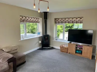 a living room with a flat screen tv and a couch at Porth Beach Lodge in Saint Columb Minor