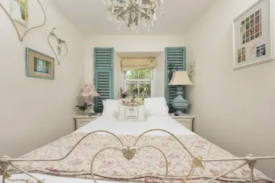 a bedroom with a bed and a chandelier at Almond Cottage - Pets welcome - Free Parking - Garden in Hayle
