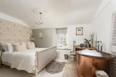 a bedroom with a bed and a tub in it at Almond Cottage - Pets welcome - Free Parking - Garden in Hayle