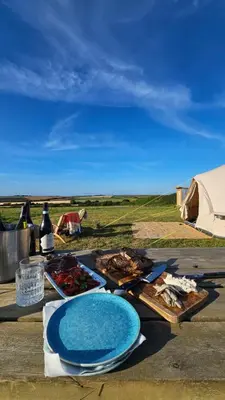 a table with plates of food and bottles of wine at Tiny Treamble in Cubert